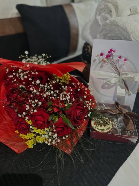 Buquê de rosas e caixa de bombons preparados para um casal na Pousada do Figa