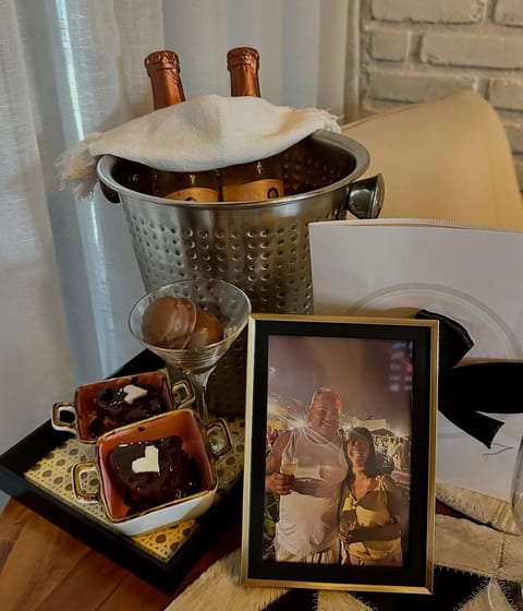 Dois espumantes no gelo, bombons, sobremesa de chocolate com coração e o retrato do casal nos 30 anos de casados, na Pousada do Figa