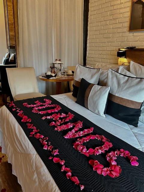 Pétalas de rosa sobre a cama formando 30 anos, surpresa de aniversário na Pousada do Figa