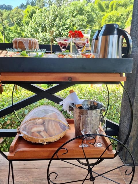 Carrinho do café da manhã com bolo, pães e espumante na varanda do Chalé Master da Pousada do Figa
