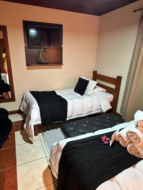 Quarto Triplo da Pousada do Figa com cama de casal, cama de solteiro e banco de couro