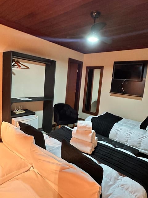Quarto Triplo da Pousada do Figa com arara, frigobar, TV e as duas camas