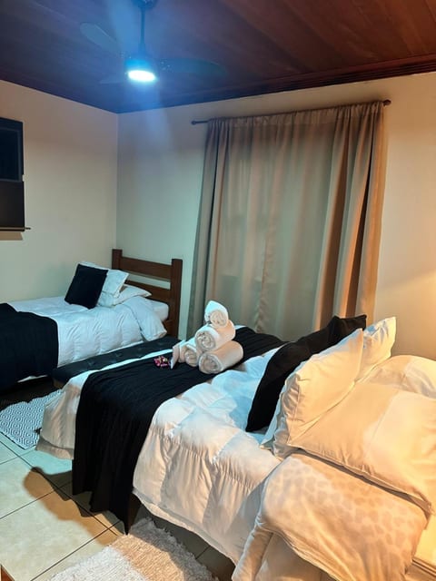 Quarto Triplo da Pousada do Figa visto da porta, com as duas camas arrumadas